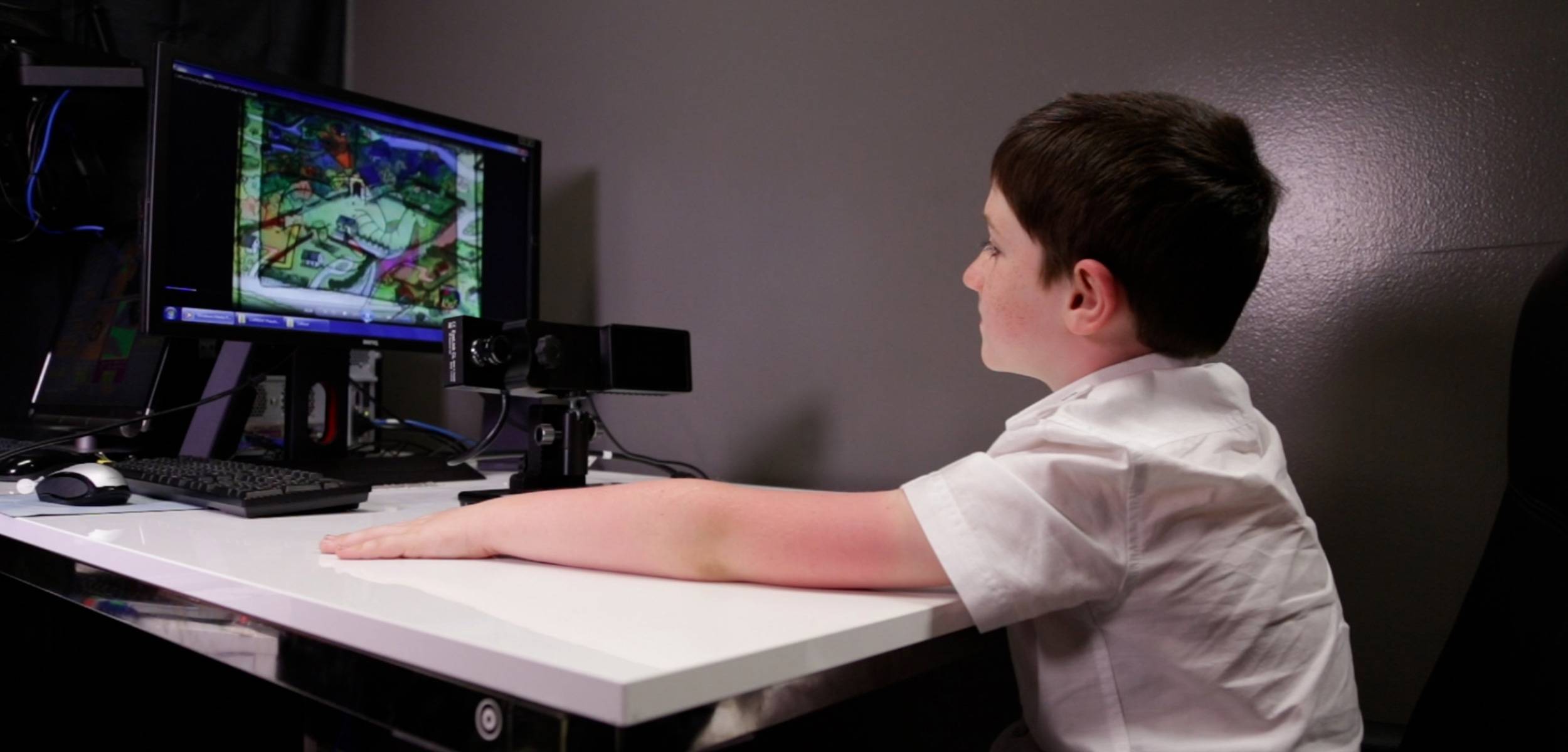Child participating in a neuroscience research activity while seated at a lab workstation.