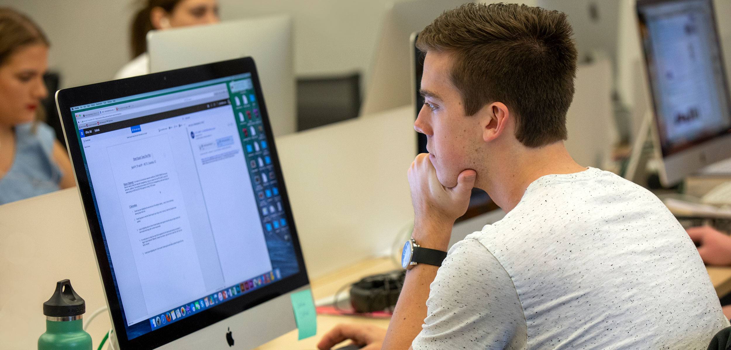 Male student sits in front of a computer