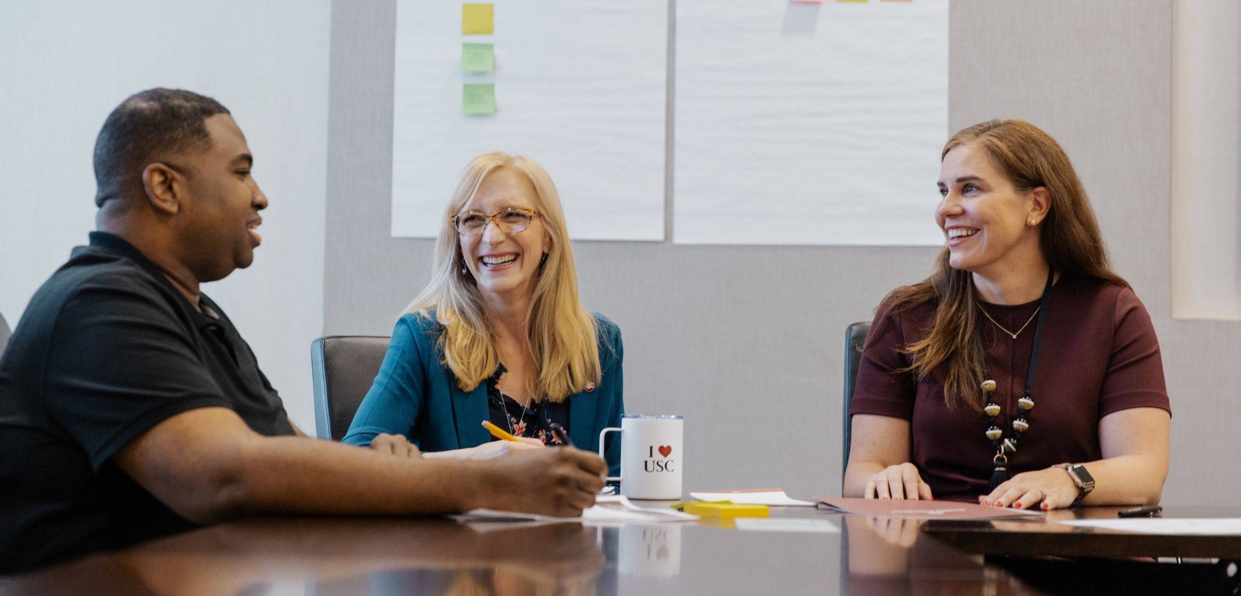 Group of employees talking at a table. 