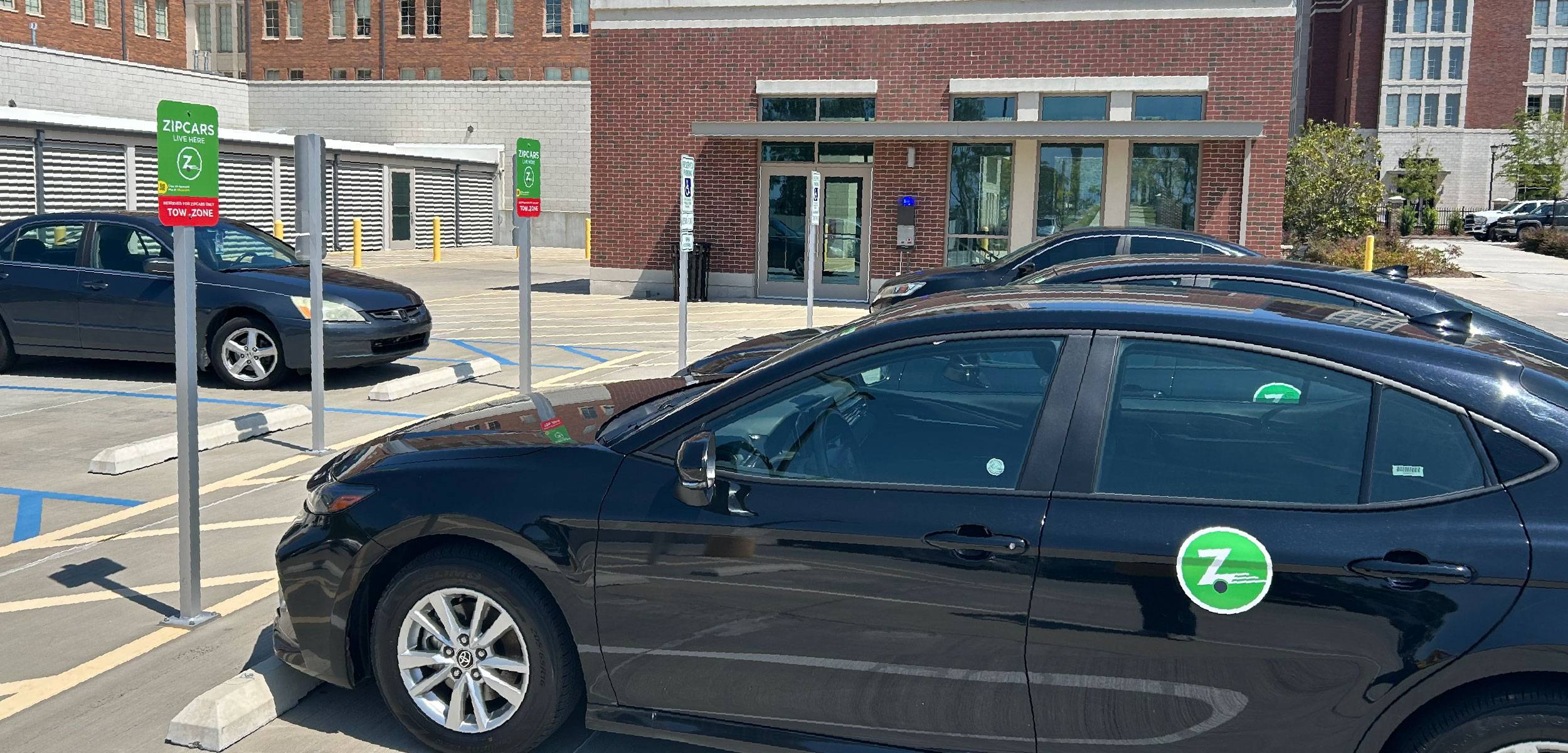 Zip Car parked in a reserved meter space.