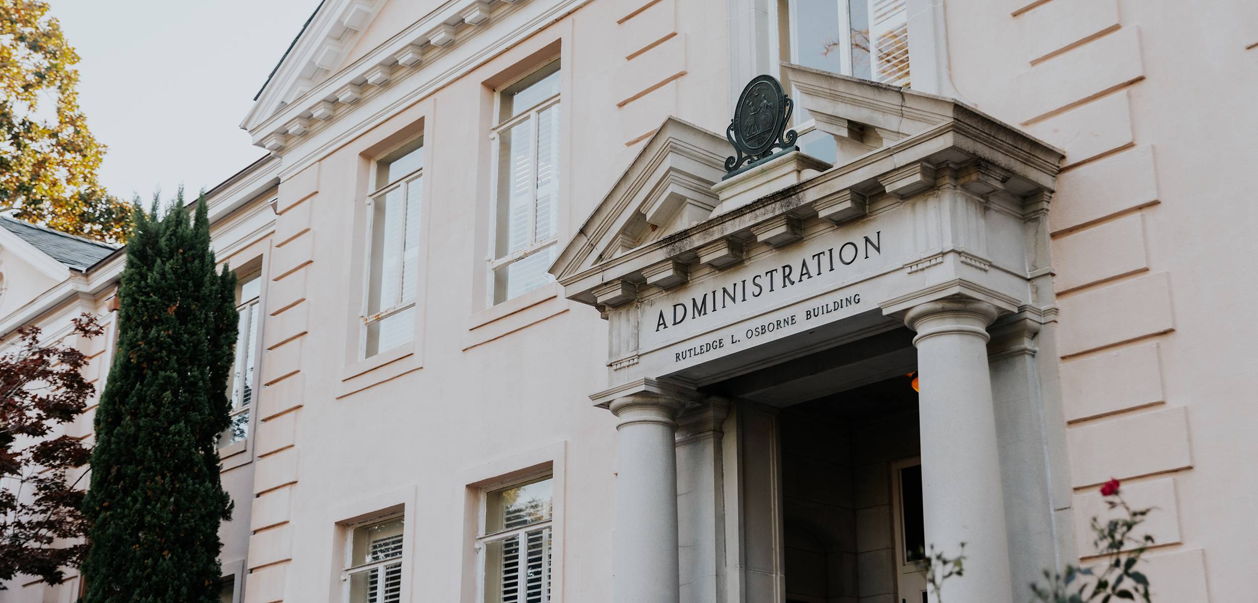 Exterior view of the University of South Carolina's Rutledge L. Osborne Administration Building, showing its white neoclassical facade, columned entrance, and 