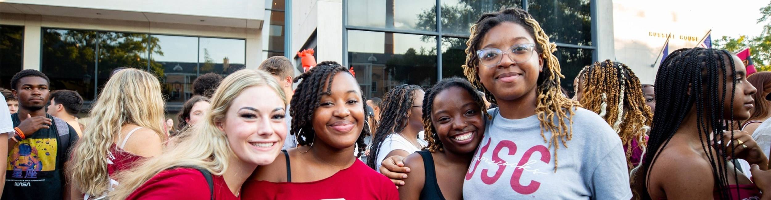 Four students standing in front of Russell House 