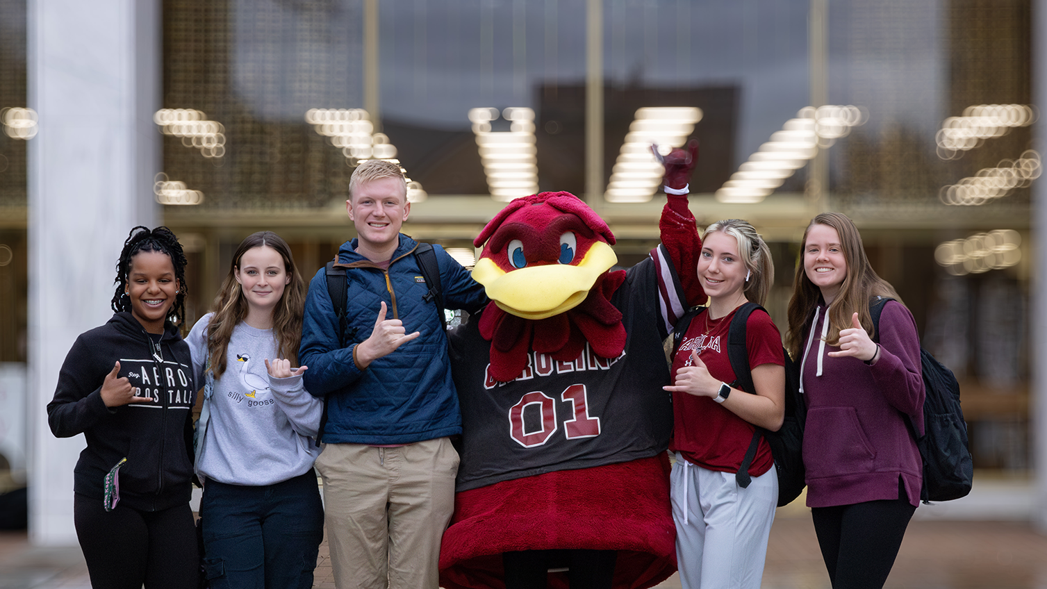 students with cocky in front of the library