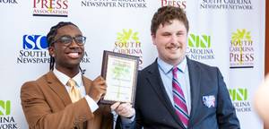 CJ Leathers and Miles Shea holding up award