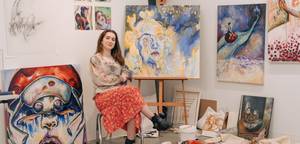 BARSC student Abby Short sitting with her artwork surrounding her.