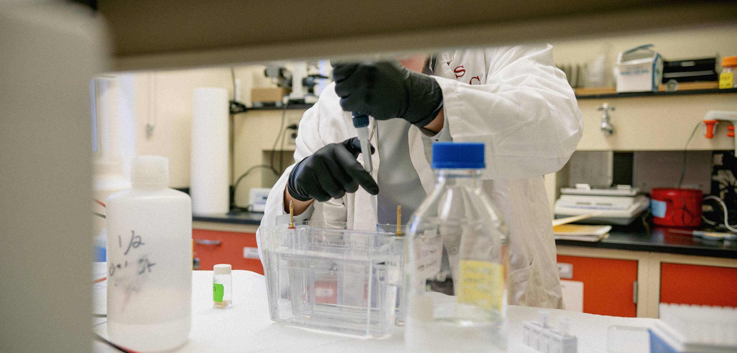 Student using a pipette in a lab.