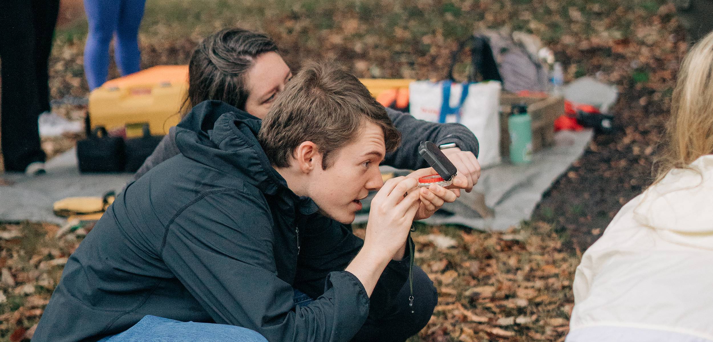 Student using a compass during an archeological dig