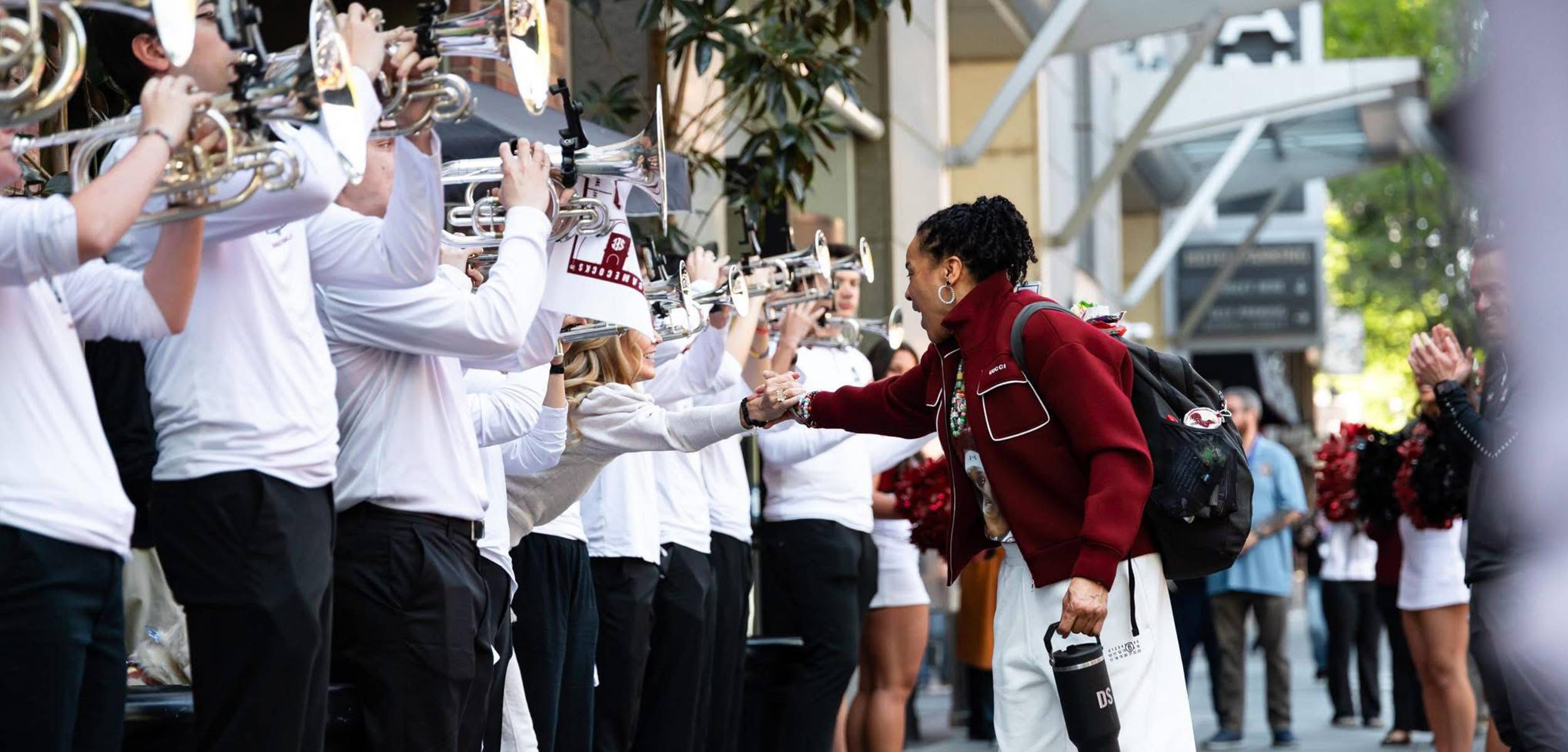 Coach Dawn Staley greets members of Carolina Basketball Band as the team enters Colonial Life Arena