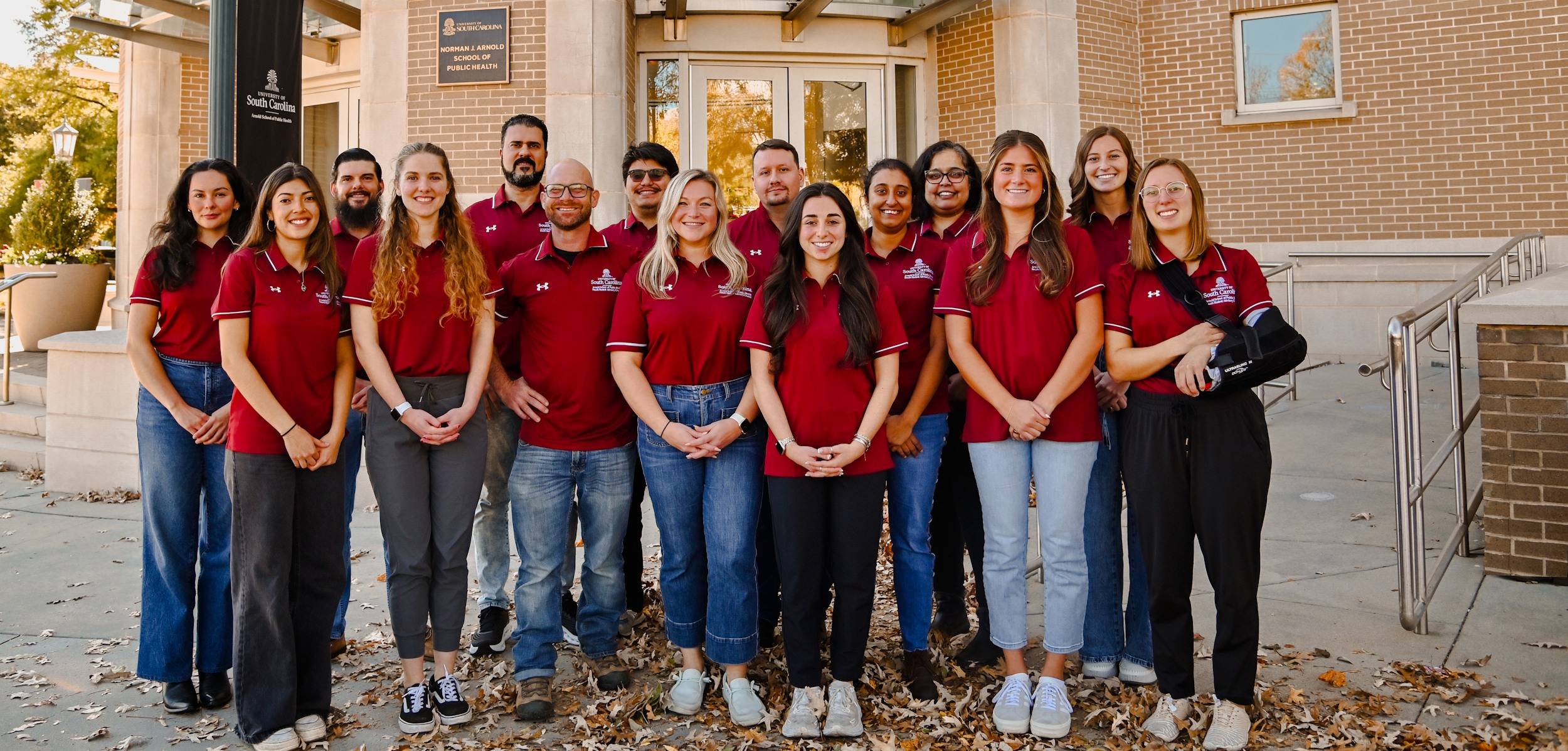 Students smiling outside of public health building