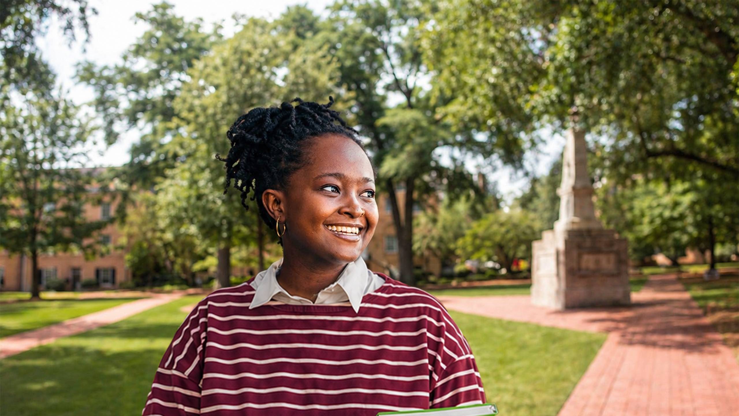 student smiling on campus horseshoe